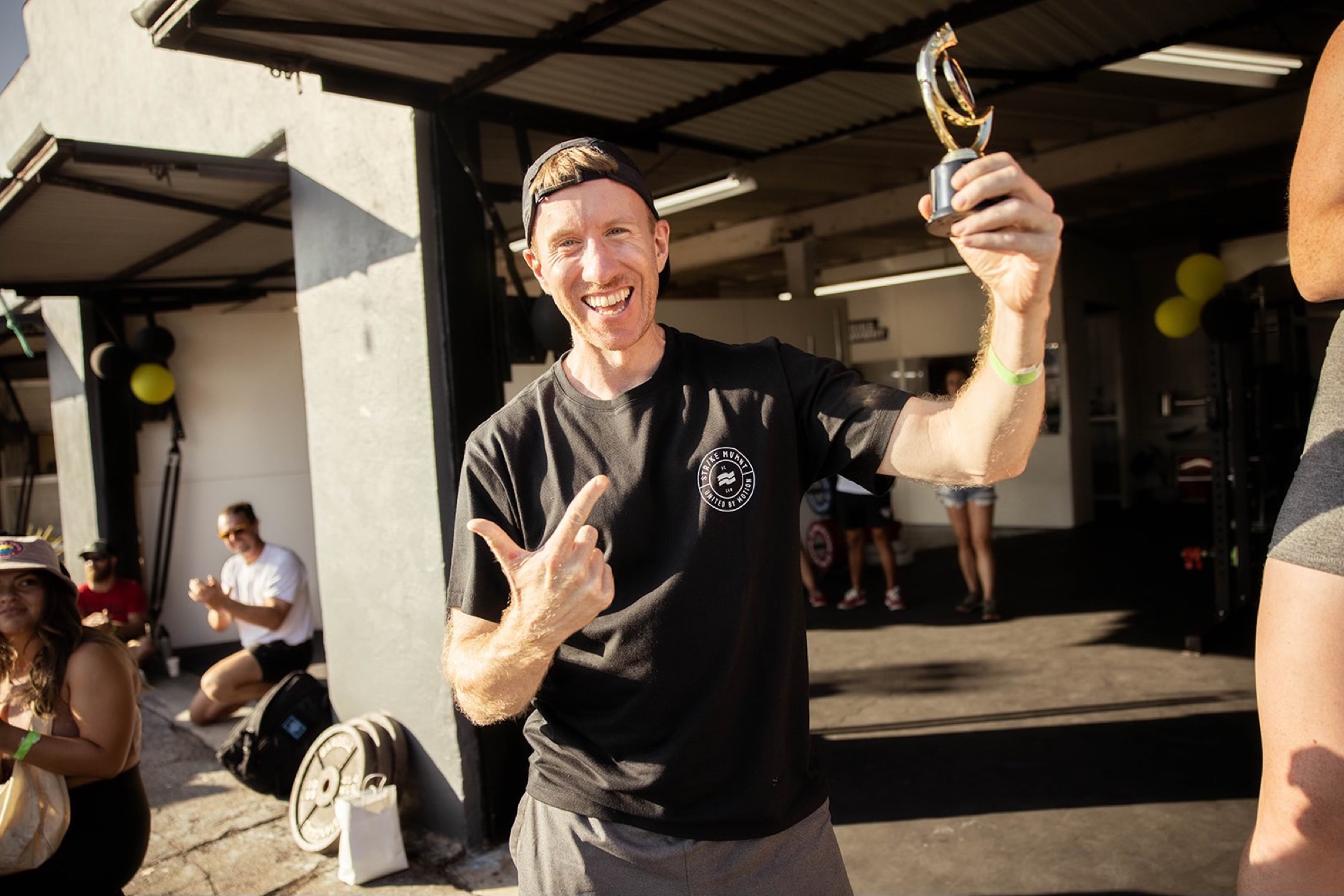 A grinning competitor holds a small trophy at the post-event party.